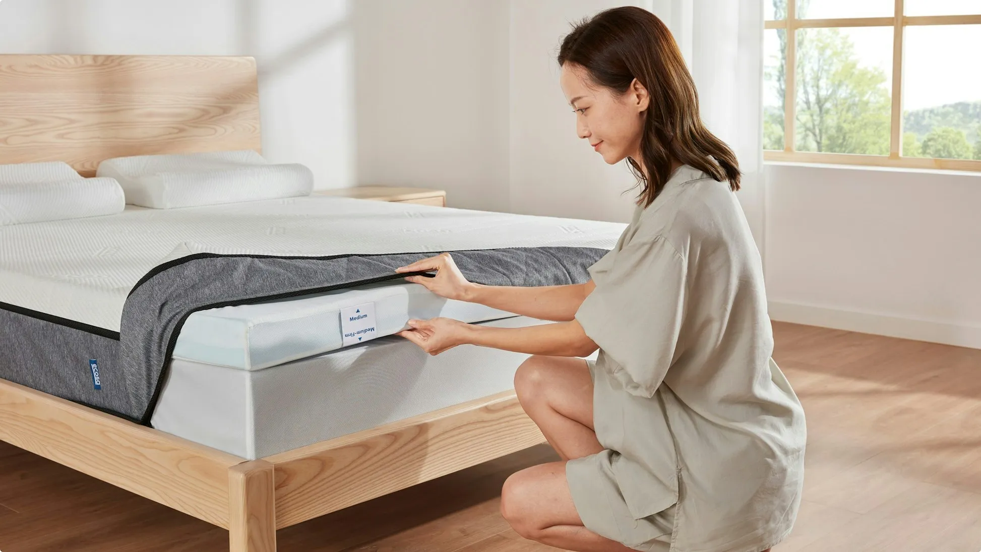 Ecosa Mattress 3 layers A woman kneeling next to a reverse the mattress layer of ecosa mattress.