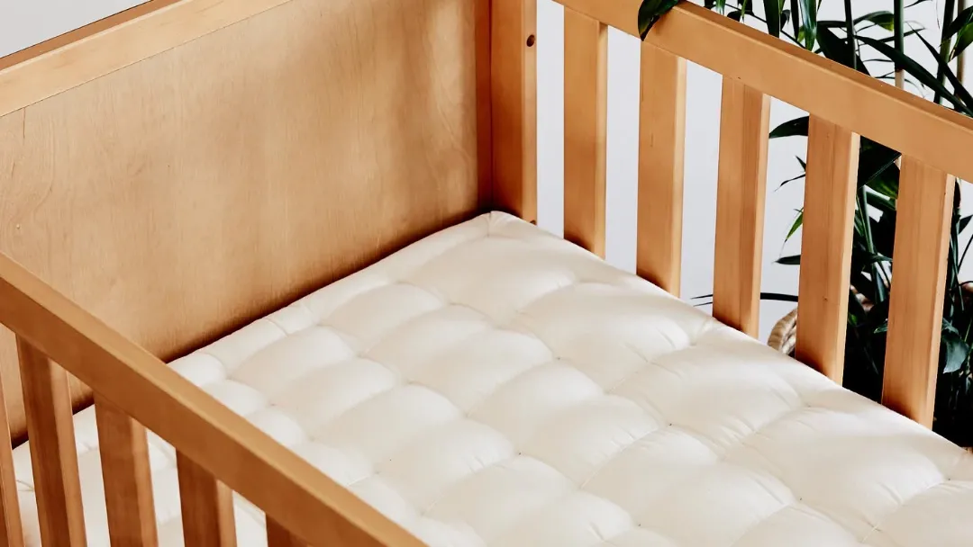 Organic & Natural Cot Mattress organic and natural cot mattress inside a wooden crib, crafted by The Natural Bedding Company.